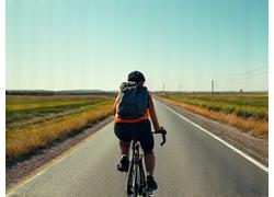 Female cyclist on a rural highway with fully loaded touring bike